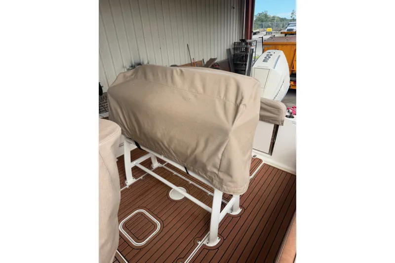 Slide: The Image of 2024 Scout 240 XSF boat interior with covered seating and wooden flooring. - 10
