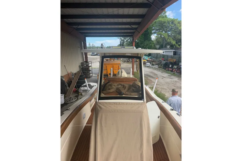 Slide: The Image of 2024 Scout 240 XSF boat under a metal shelter, with outdoor equipment visible. - 29