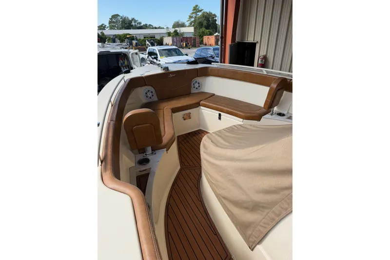 Slide: The Image of 2024 Scout 240 XSF boat interior with tan seating and wood flooring. - 13