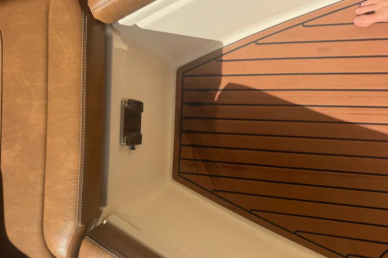 Slide: The Image of 2024 Scout 240 XSF boat interior with brown leather seating and wood-patterned flooring. - 35
