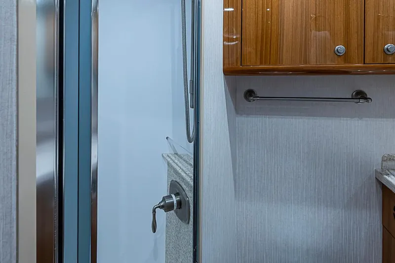 Slide: The Image of 2021 Viking 38 Open yacht bathroom with sleek shower and wooden cabinetry. - 20