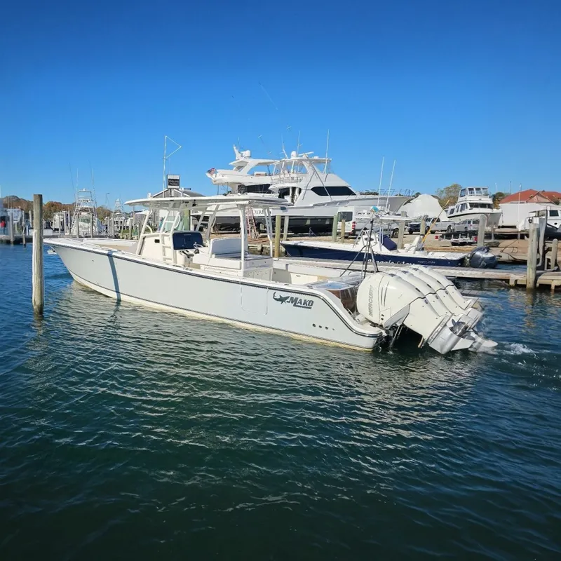 The Image of 2019 Mako 414 Center Console boat docked in a marina under clear blue skies. - 0