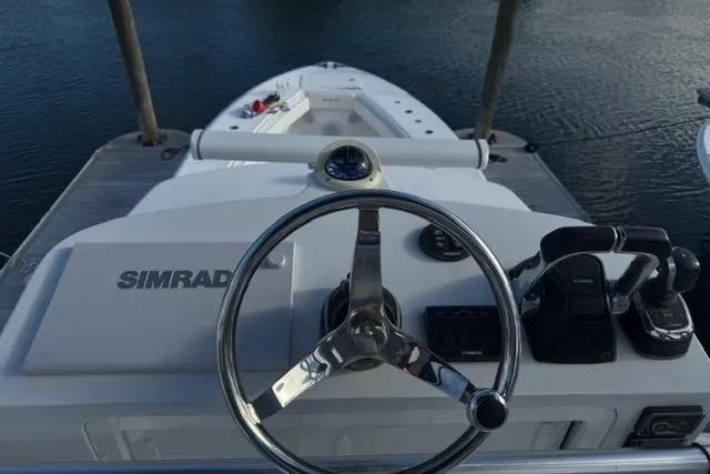 Slide: The Image of 2015 SeaHunter Center Console boat helm with Simrad navigation system, docked on calm water. - 2