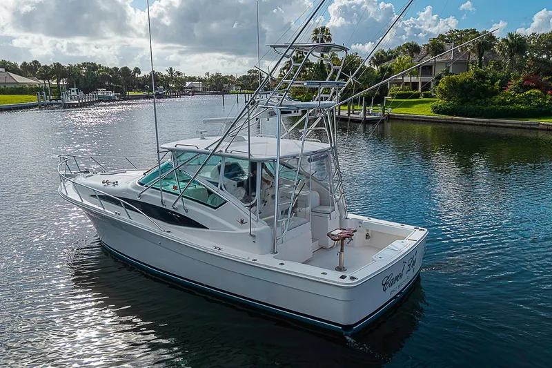 Slide: The Image of 2008 Bertram 360 yacht on a serene waterway under a partly cloudy sky. - 8