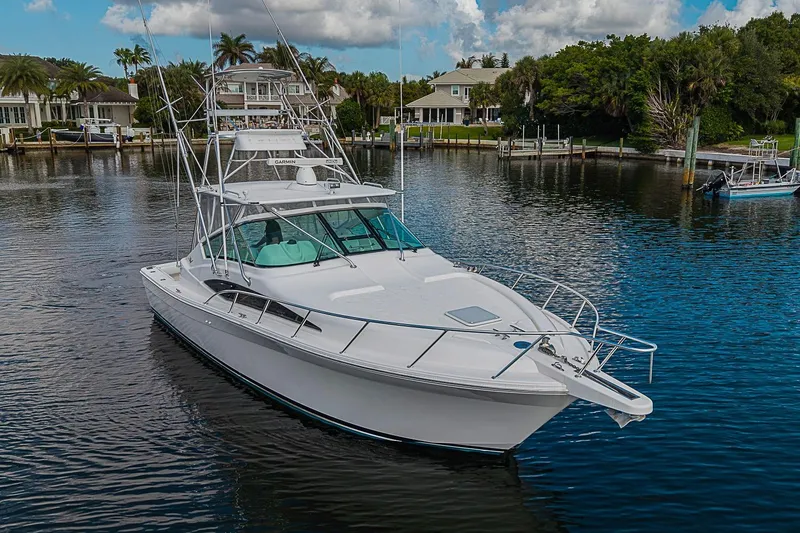 Slide: The Image of 2008 Bertram 360 yacht on calm water near waterfront homes. - 4
