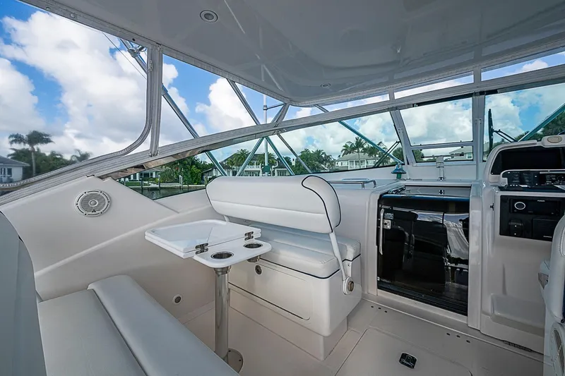 Slide: The Image of Interior of a 2008 Bertram 360 yacht with seating and helm, under a clear sky. - 46