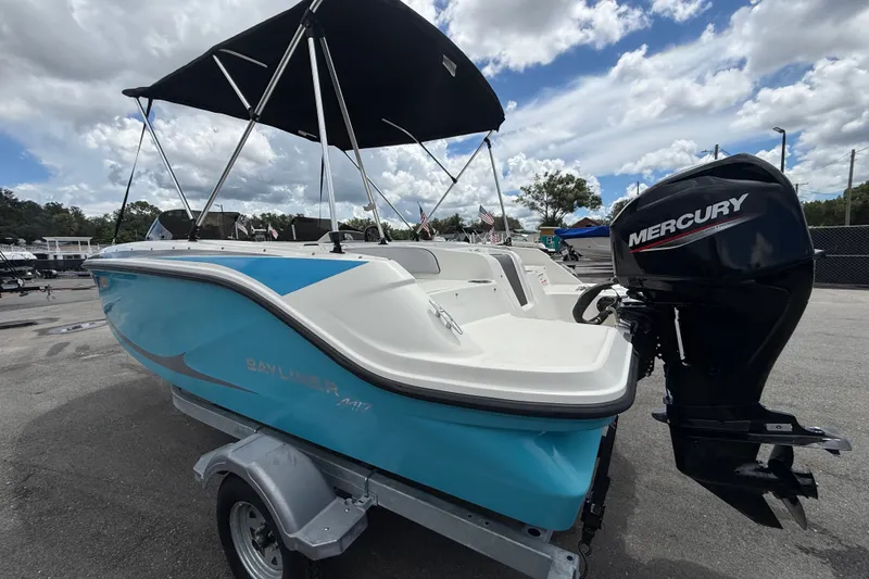 Slide: The Image of 2024 Bayliner Element M17 boat with Mercury engine on trailer under cloudy sky. - 9