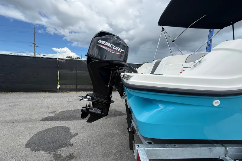 Slide: The Image of 2024 Bayliner Element M17 boat with Mercury outboard motor, parked on a trailer. - 3