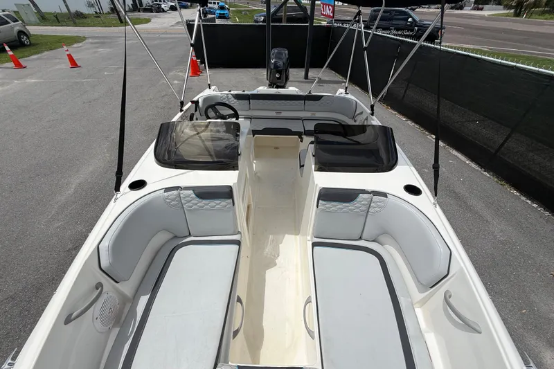 Slide: The Image of 2024 Bayliner Element M17 boat interior with seating and steering wheel, parked outdoors. - 36