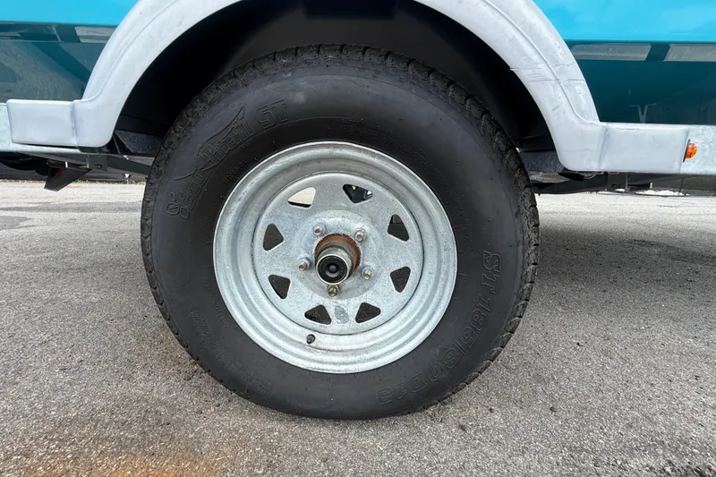 Slide: The Image of Trailer wheel of 2024 Bayliner Element M17 boat on pavement. - 52