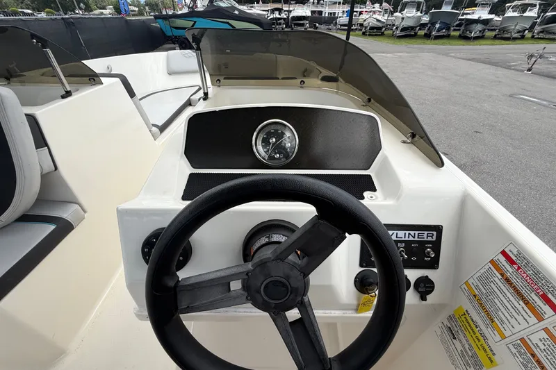 Slide: The Image of 2024 Bayliner Element M17 boat dashboard with steering wheel and gauges. - 19