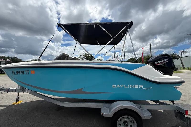 Slide: The Image of 2024 Bayliner Element M17 boat with canopy and Mercury engine, parked outdoors. - 10