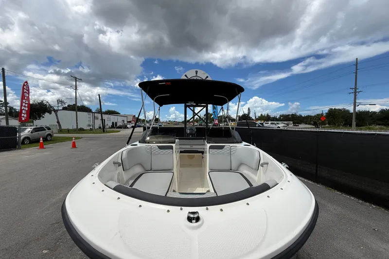 Slide: The Image of 2024 Bayliner Element M17 boat with canopy, parked outdoors under cloudy sky. - 12