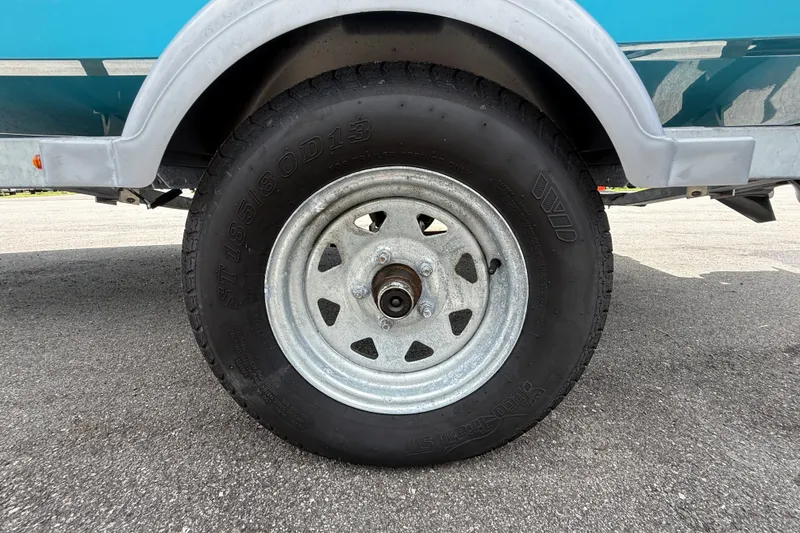 Slide: The Image of Trailer wheel of 2024 Bayliner Element M17 boat on pavement. - 53