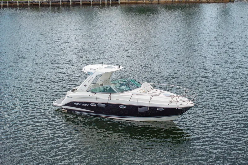 Slide: The Image of 2014 Monterey 320 Sport Yacht on calm water, showcasing sleek design and luxury features. - 5