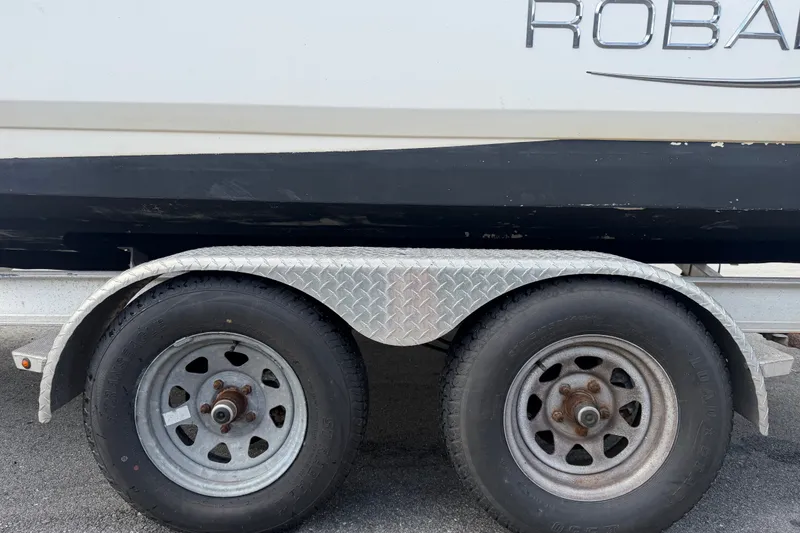 Slide: The Image of Trailer with dual wheels carrying a 2019 Robalo 226 Cayman boat. - 83