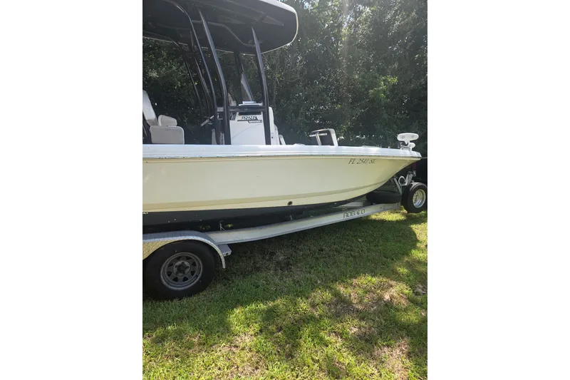 Slide: The Image of 2019 Robalo 226 Cayman boat on trailer, parked on grass, side view. - 2