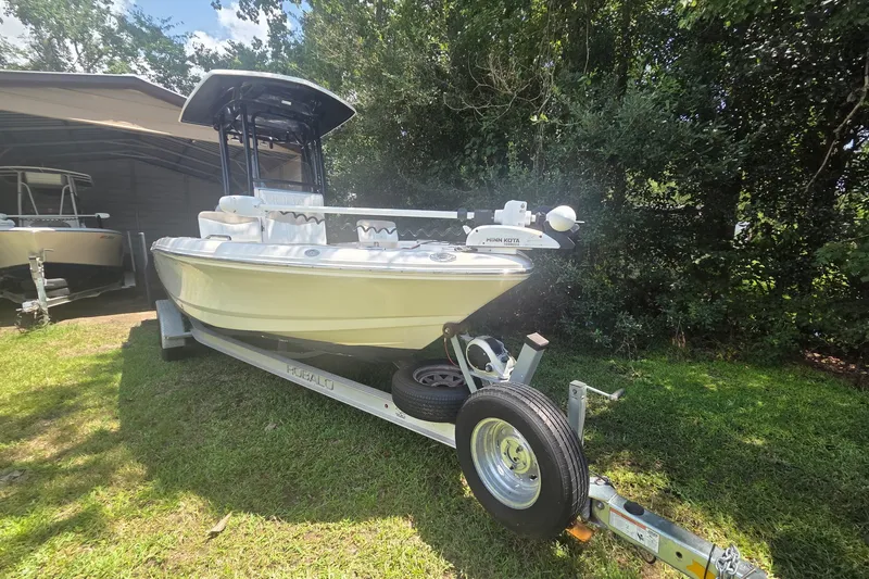 Slide: The Image of 2019 Robalo 226 Cayman boat on trailer, parked on grass near trees. - 1