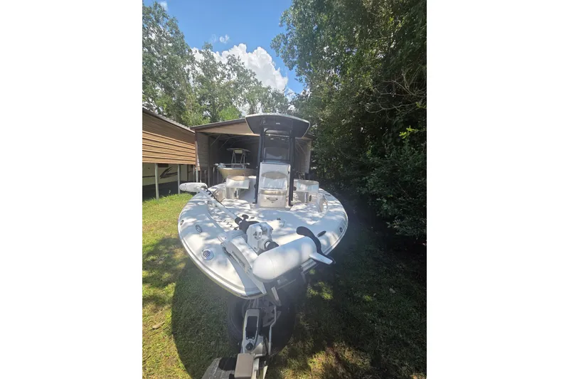 Slide: The Image of 2019 Robalo 226 Cayman boat parked outdoors near trees and a shed. - 4