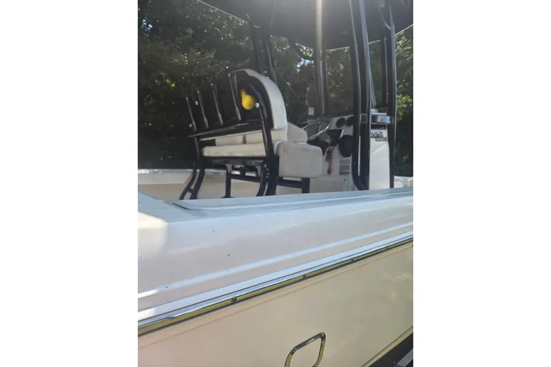 Slide: The Image of 2019 Robalo 226 Cayman boat interior with seating and console, under sunlight. - 5