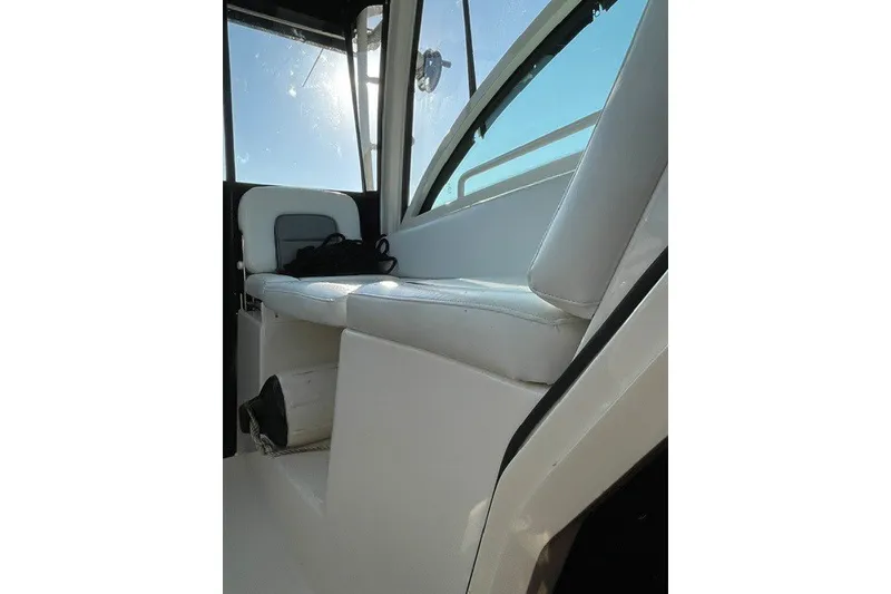 Slide: The Image of Interior seating of 2012 Boston Whaler 285 Conquest boat, featuring white upholstery. - 13