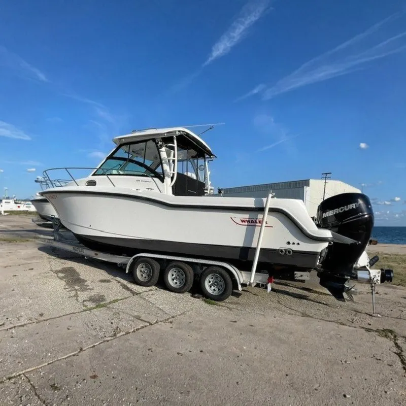 The Image of A 2012 Boston Whaler 285 Conquest on a trailer by the shore. - 0