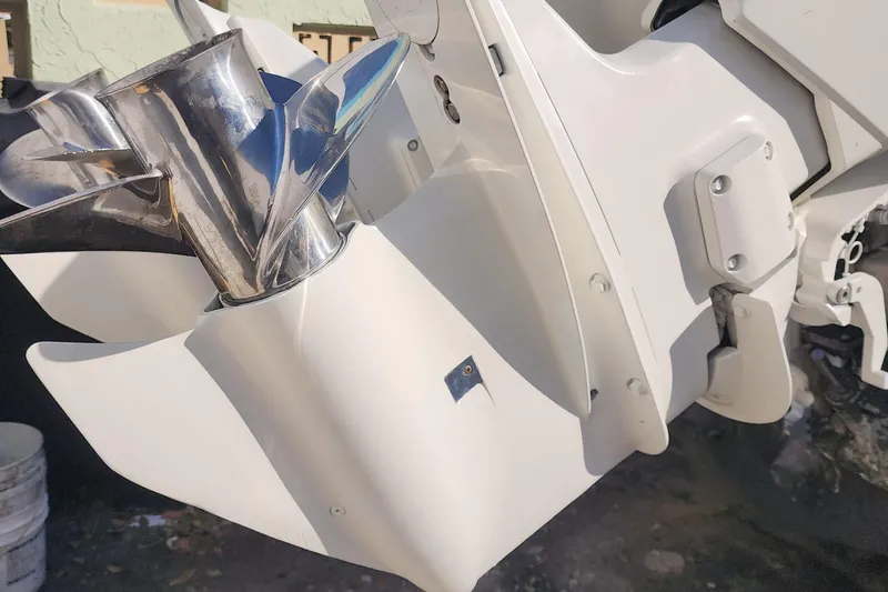 Slide: The Image of Close-up of a 1997 Dusky 256 CC boat's shiny metal propeller and white motor housing. - 16