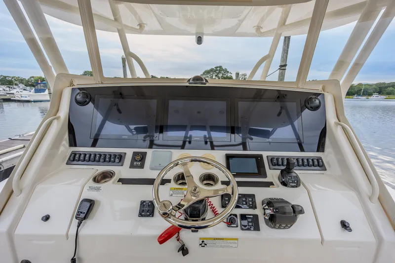 Slide: The Image of 2018 Regulator 41 boat helm with advanced navigation controls and steering wheel. - 12