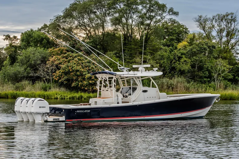 Slide: The Image of 2018 Regulator 41 boat with Yamaha engines on a calm river, surrounded by lush greenery. - 11