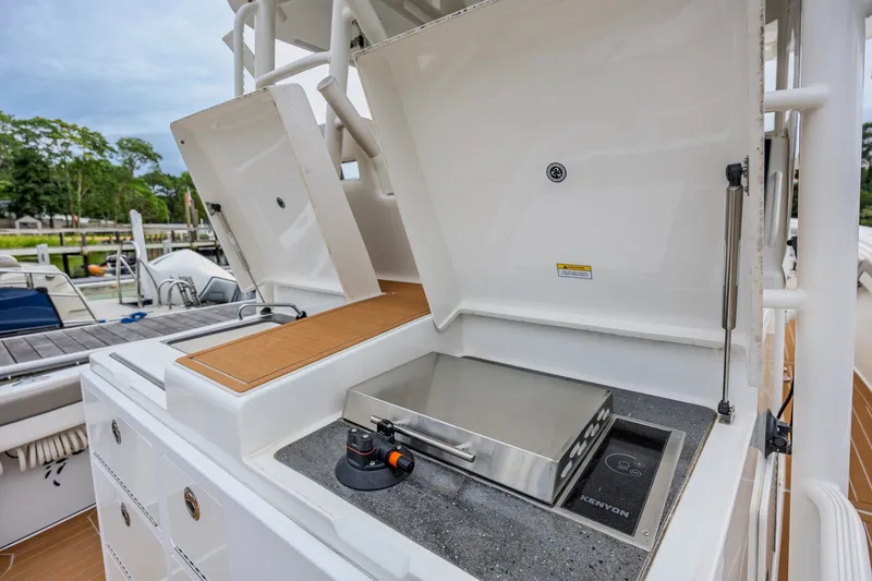 Slide: The Image of Outdoor grill station on 2018 Regulator 41 boat, featuring Kenyon grill and storage compartments. - 15