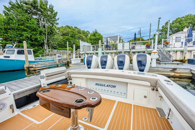 Slide: The Image of 2018 Regulator 41 boat docked, featuring spacious deck and four powerful engines. - 18