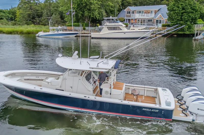 Slide: The Image of 2018 Regulator 41 boat on water near docked vessels and waterfront homes. - 9