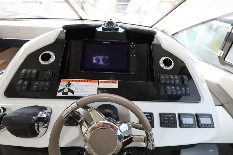 Slide: The Image of 2019 Beneteau Gran Turismo 50 helm with steering wheel, controls, and navigation display. - 22