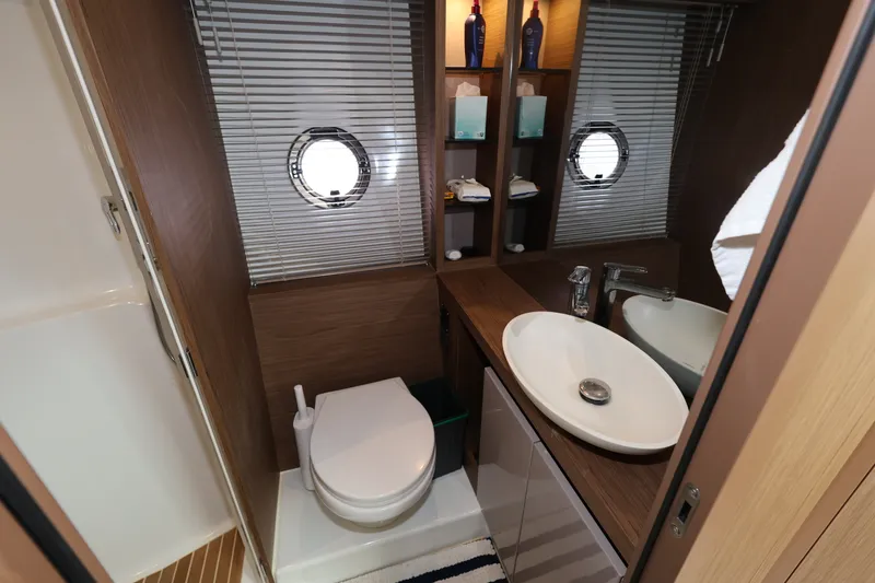Slide: The Image of Luxurious bathroom in 2019 Beneteau Gran Turismo 50 yacht, featuring modern fixtures and porthole windows. - 28