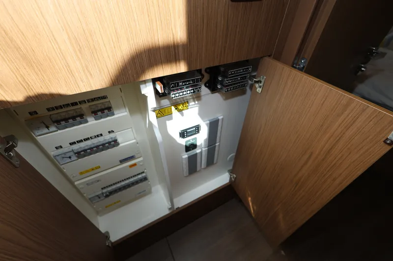 Slide: The Image of Electrical panel inside 2019 Beneteau Gran Turismo 50 yacht, wooden cabinet open. - 36
