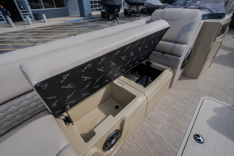 Slide: The Image of 2023 Crest Caribbean LX 250 boat interior with open storage compartment and seating. - 54