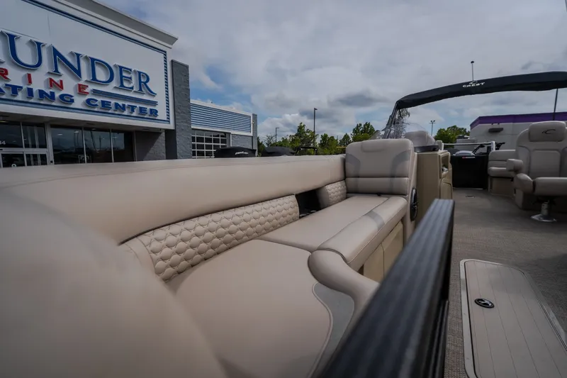 Slide: The Image of 2023 Crest Caribbean LX 250 pontoon boat with luxurious seating at a marine center. - 45