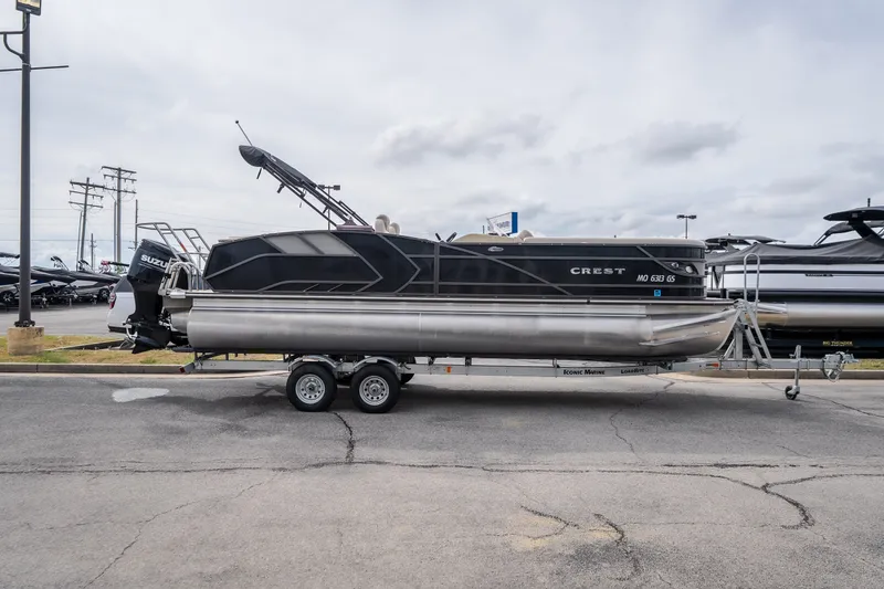 Slide: The Image of 2023 Crest Caribbean LX 250 pontoon boat on trailer in parking lot. - 17