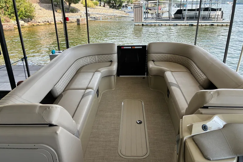 Slide: The Image of 2023 Crest Caribbean LX 250 pontoon boat interior with plush seating and lake view. - 16