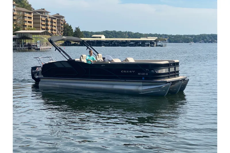 Slide: The Image of 2023 Crest Caribbean LX 250 pontoon boat on a serene lake. - 61