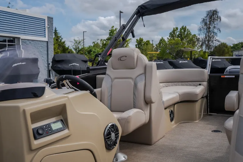 Slide: The Image of 2023 Crest Caribbean LX 250 boat interior with beige seating and modern dashboard. - 46