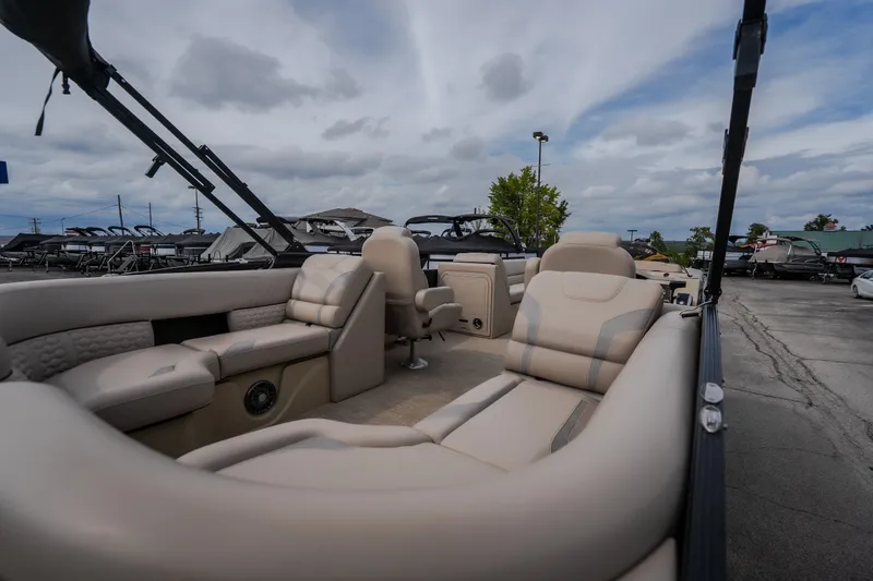 Slide: The Image of 2023 Crest Caribbean LX 250 pontoon boat with luxurious seating, displayed outdoors. - 32