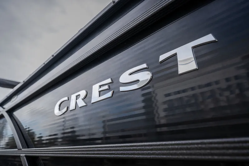 Slide: The Image of 2023 Crest Caribbean LX 250 boat logo on sleek black surface. - 20