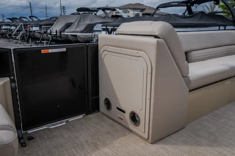 Slide: The Image of 2023 Crest Caribbean LX 250 boat interior with beige seating and storage compartment. - 37