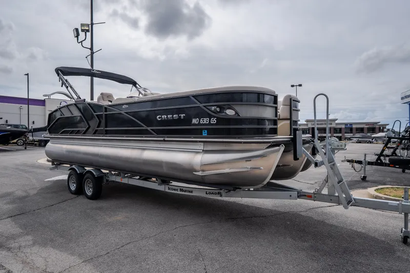 Slide: The Image of 2023 Crest Caribbean LX 250 pontoon boat on trailer in parking lot. - 18