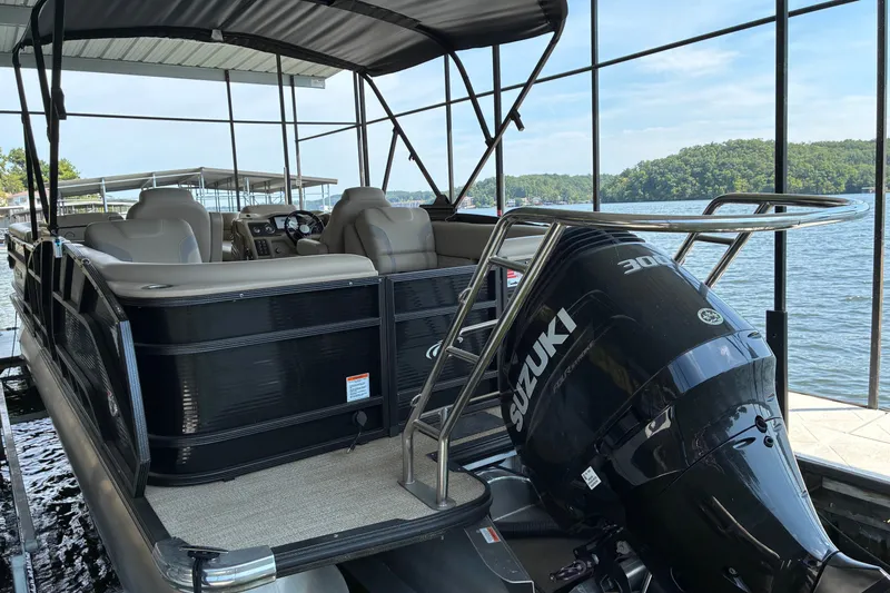 Slide: The Image of 2023 Crest Caribbean LX 250 pontoon boat with Suzuki engine, docked by a scenic lake. - 13