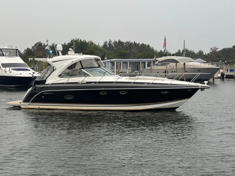 Slide: The Image of 2016 Formula 40 Performance Cruiser on the water, sleek design, with other boats in the background. - 2