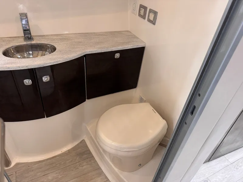 Slide: The Image of The image shows a modern boat bathroom with a toilet and a sink. - 26