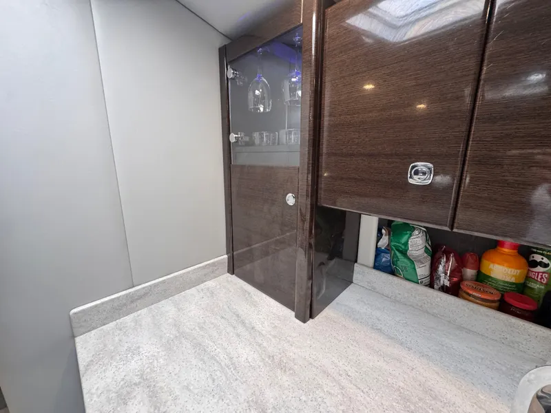 Slide: The Image of The galley of a 2016 Formula 40 Performance Cruiser with dark wood cabinets and a glass display case. - 28