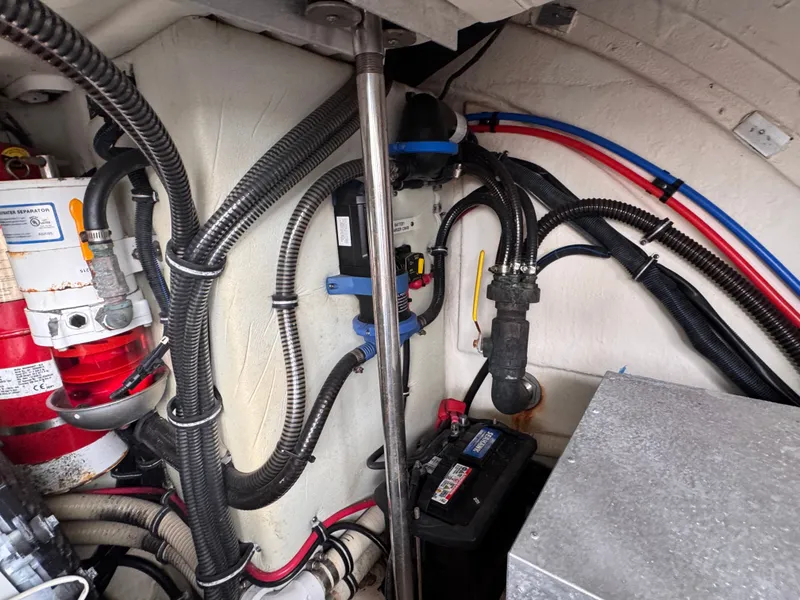 Slide: The Image of View of the engine room with cables, hoses, and a battery. - 33